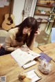 A woman sitting at a table reading a book.