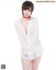 A woman in a white shirt is posing for a picture.