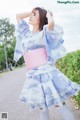 A woman in a blue and pink kimono is posing for a picture.