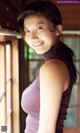 A woman in a purple tank top posing for a picture.