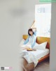 A woman sitting on a bed with a tray of food.