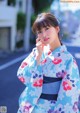 A woman in a blue and pink kimono posing for a picture.