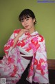 A woman in a pink and white kimono posing for a picture.