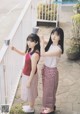 Two young women standing next to each other on a balcony.