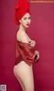 A woman in a red turban is posing for a picture.