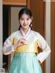 A woman wearing a yellow and green hanbok.