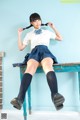 A woman in a school uniform sitting on a bench.