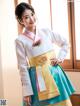 A woman in a hanbok is posing for a picture.