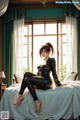 A woman sitting on a bed in a room.