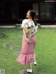 A woman in a red and white polka dot skirt holding a bouquet of flowers.