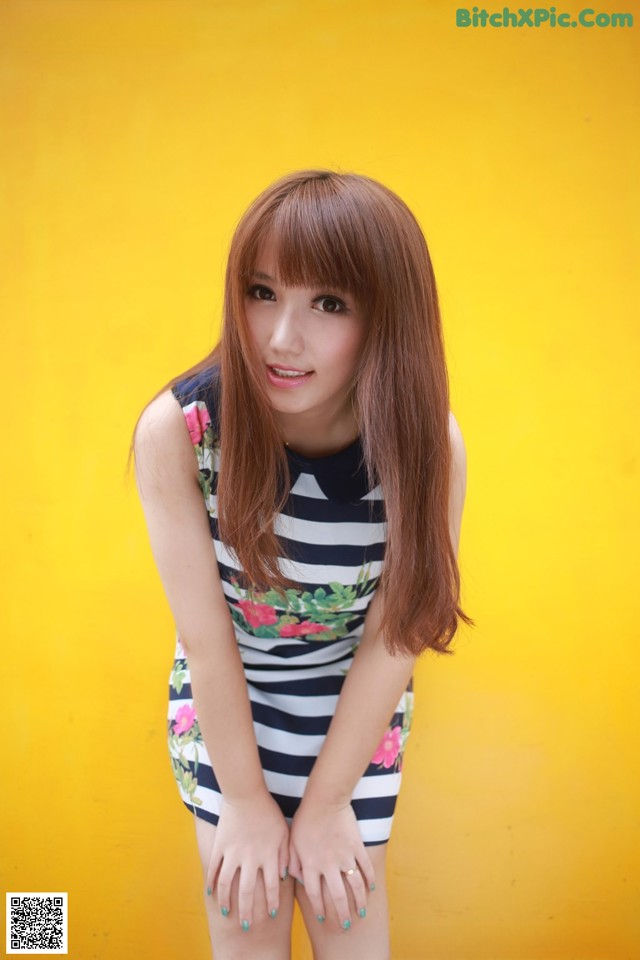 A woman in a striped dress posing for a picture.