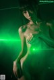 A naked woman with a green light shining on her body.